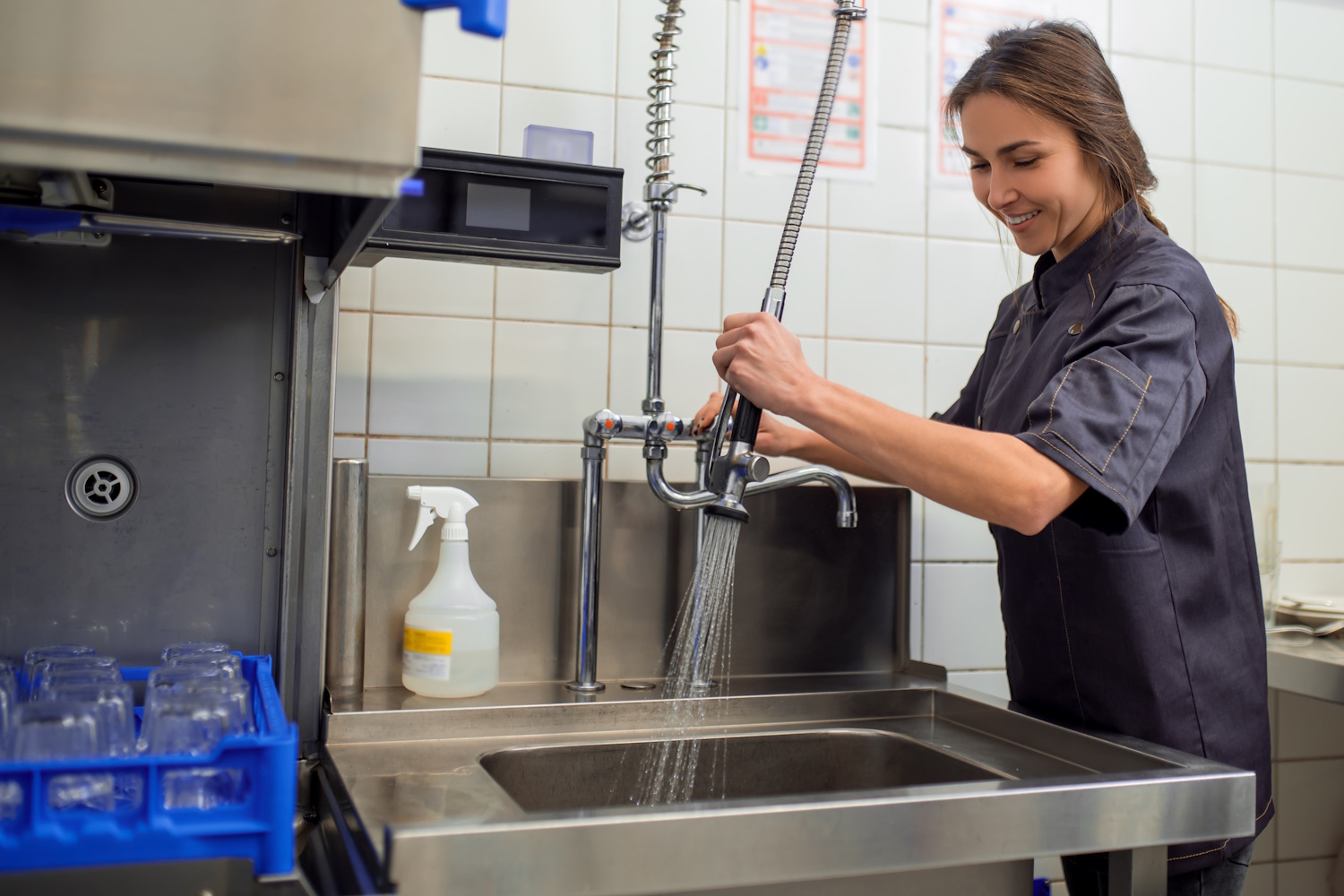 Young woman cleaning dishes in the kitchen